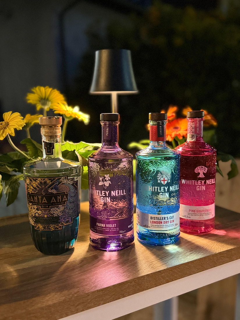 Bottiglie di gin sul ripiano del bar, illuminate dalla lampada