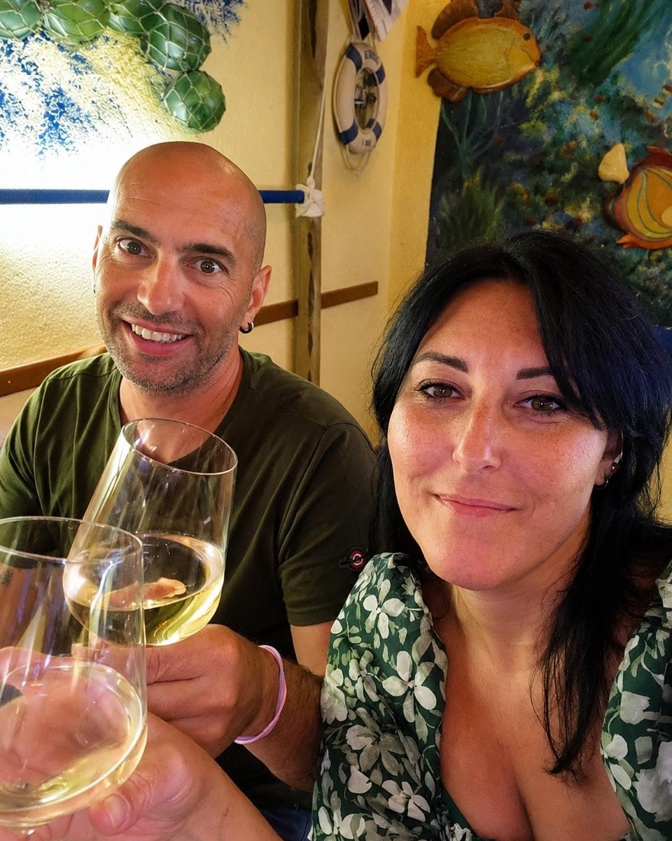Leonardo e Barbara, titolari della trattoria pizzeria, brindano nella sala del locale